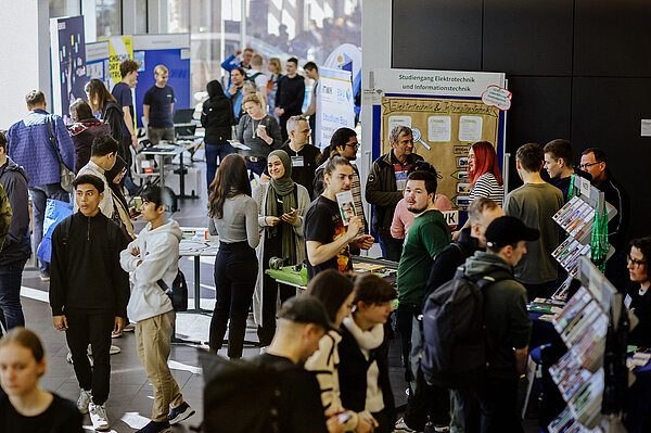 Menschenmenge in einem Foyer an Ständen