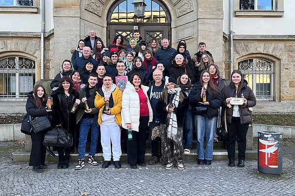 Gruppenfoto vor einem HTWK-Gebäudeeingang mit vielen jungen Menschen